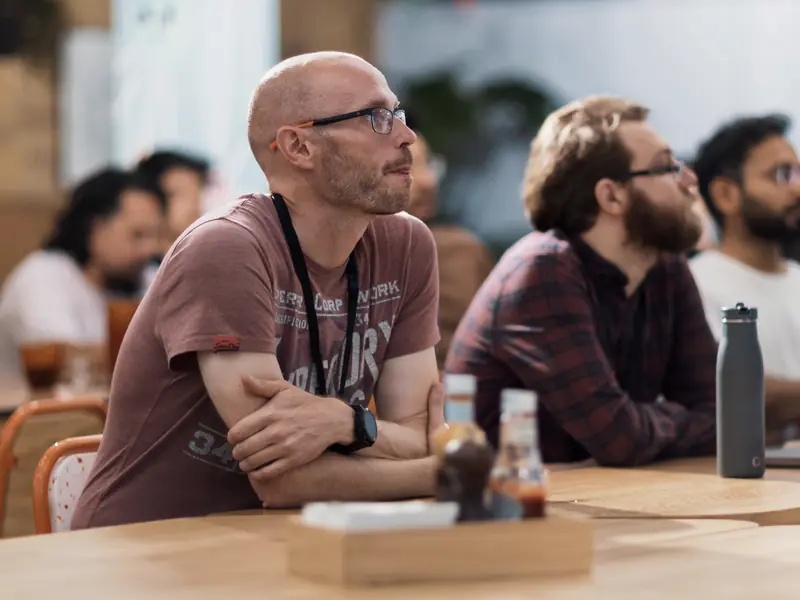 Attendees listening at a table